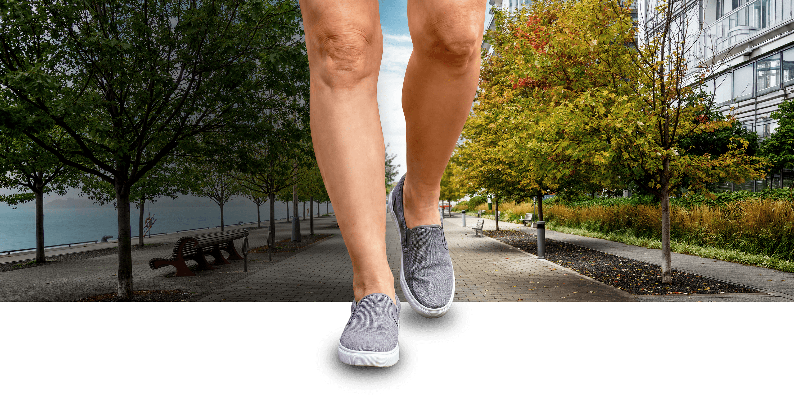 Une paire de jambes démesurément grandes, visibles de la mi-cuisse jusqu’aux pieds, marchant sur un trottoir.