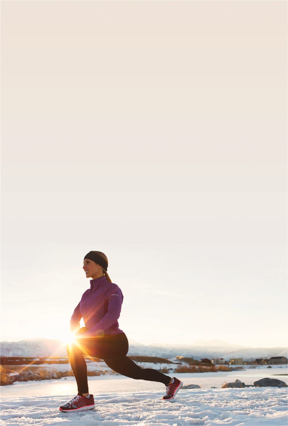 Woman stretching outdoors with sunburst at her knee